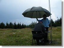 Iva obětavě drží deštník nad vysílacím stolečkem